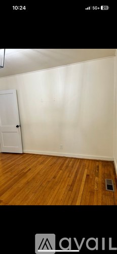 A room with wooden flooring and a white door.