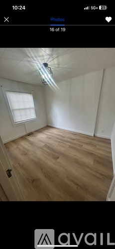 A room with wooden flooring and a window.