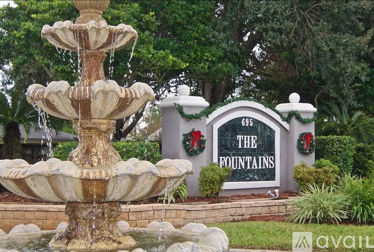 A large fountain in front of a sign that says "The Fountains".