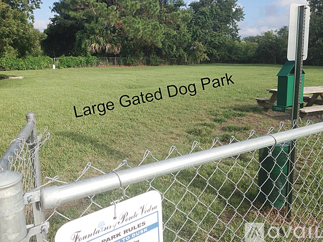 A sign at the entrance of a fenced dog park reads "Large Gated Dog Park.".