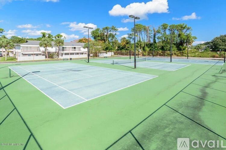 A tennis court with a green surface and white lines.