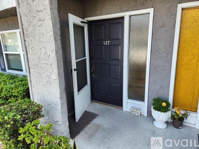 A black door with the number 127 on it is the main focus of the image.