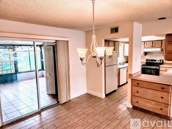 A kitchen with a chandelier and a dining table.