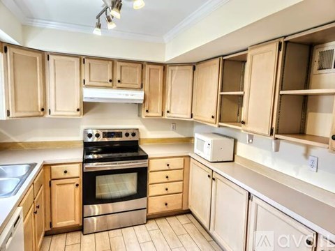 A kitchen with wooden cabinets and a stainless steel oven.