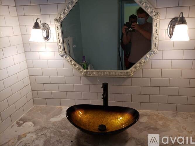 A bathroom with a black sink and a mirror above it.