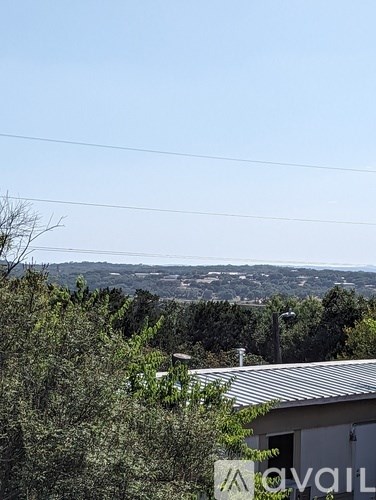 A house with a roof and a tree in front of it.