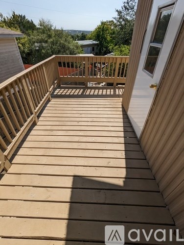 A wooden deck with a door and a window.