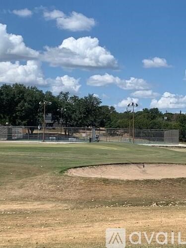 A baseball field with a cloudy sky above it.