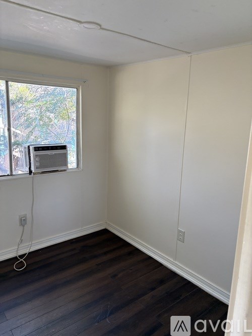 A room with a window and a white wall.