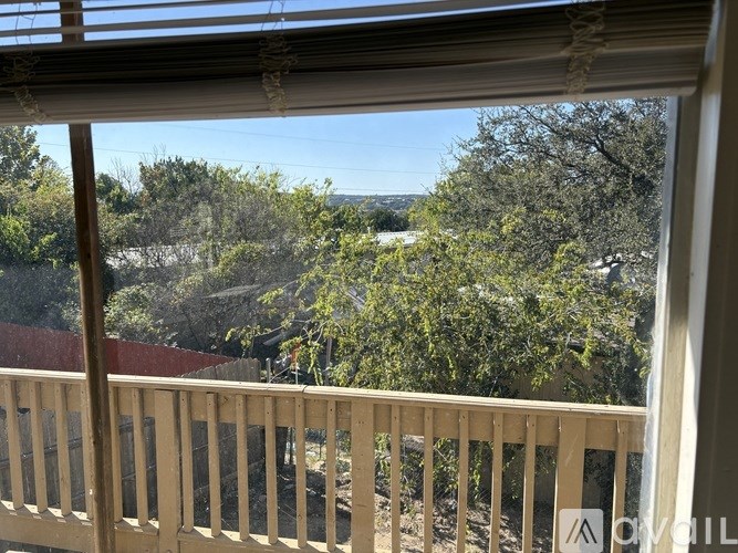 A balcony with a view of trees and a clear sky.