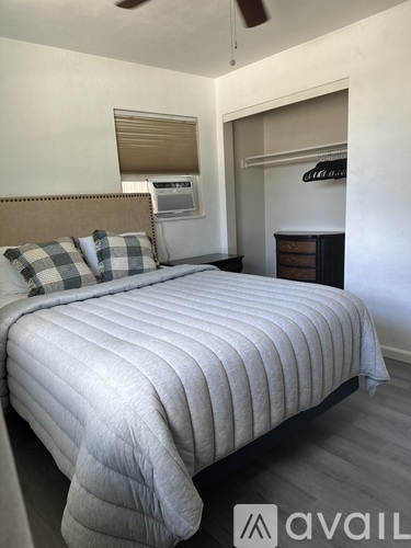 A bedroom with a large bed and a ceiling fan.