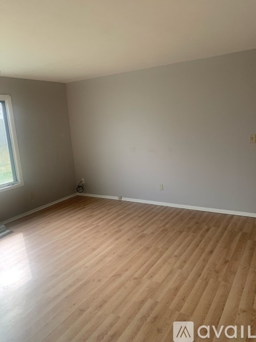 A room with wooden flooring and a window.