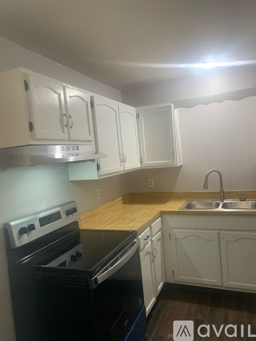A kitchen with white cabinets and a black stove top oven.