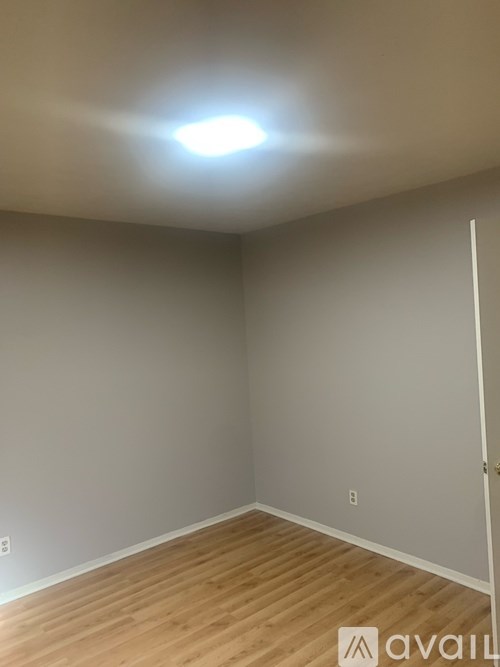 A room with wooden flooring and a light on the ceiling.