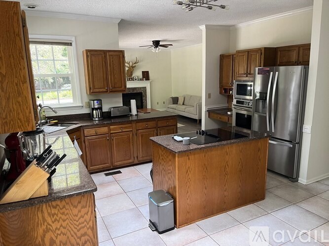 A kitchen with wooden cabinets and a stainless steel refrigerator.
