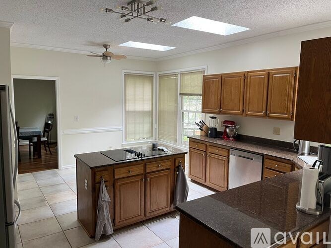 A kitchen with wooden cabinets and a black countertop.
