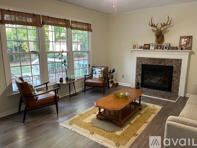 A living room with a fireplace and a deer head on the wall.