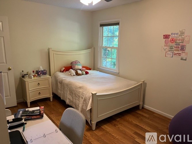 A bedroom with a bed, nightstand, and chair.