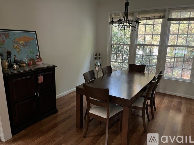 A dining room with a wooden table and chairs.
