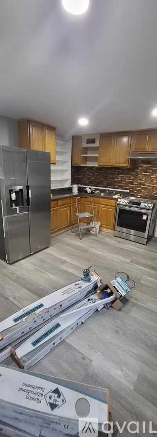 A kitchen under renovation with wooden flooring and unfinished cabinets.