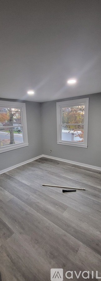 A room with grey walls and a window overlooking a street.