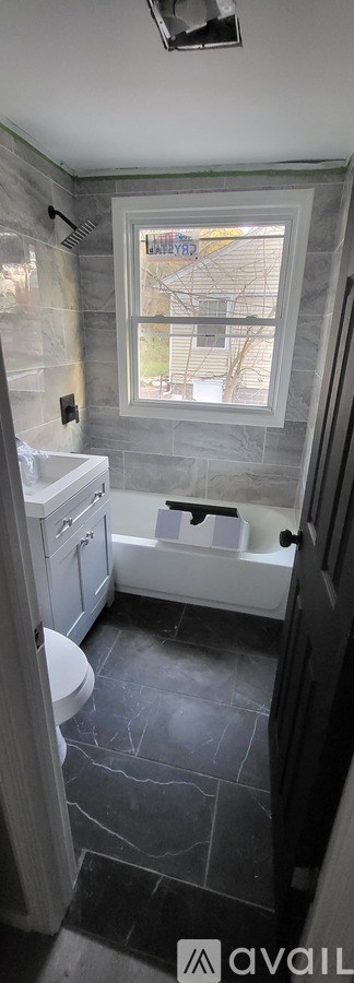 A bathroom with a toilet, sink, and tub.