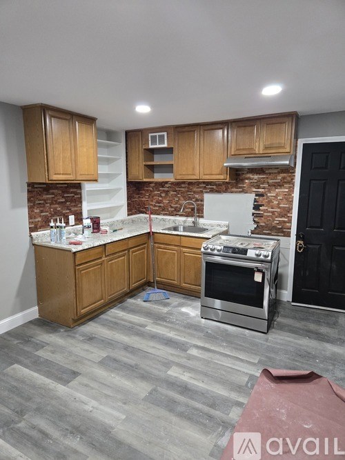 A kitchen with wooden cabinets and a brick backsplash.