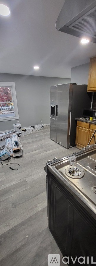 A kitchen with a refrigerator, sink, and cabinets.
