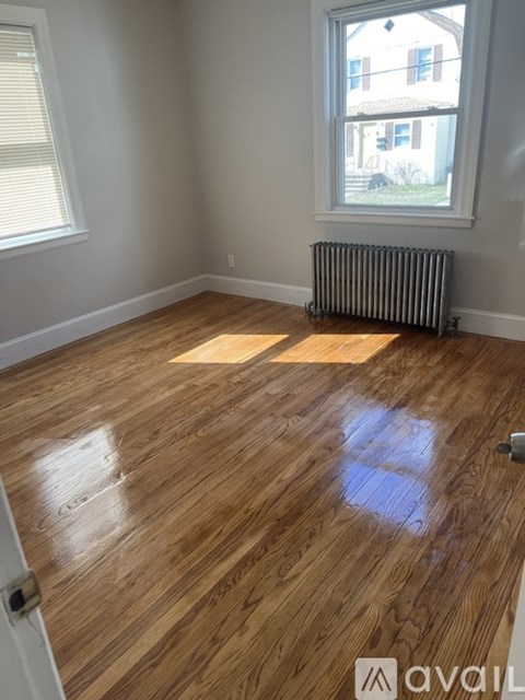 A room with wooden flooring and a window.