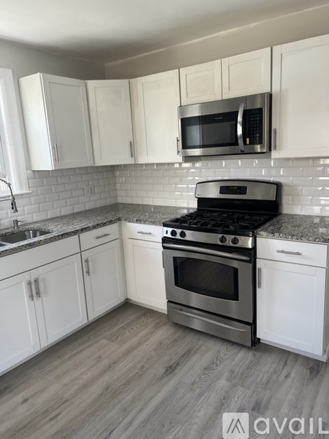 A kitchen with white cabinets and a stainless steel oven.