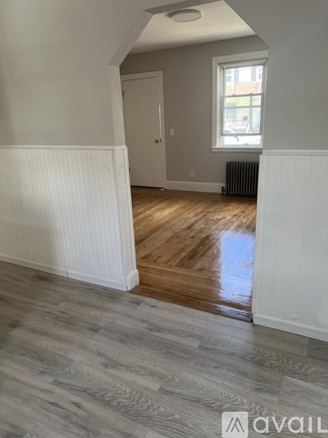 A room with wooden flooring and white walls.