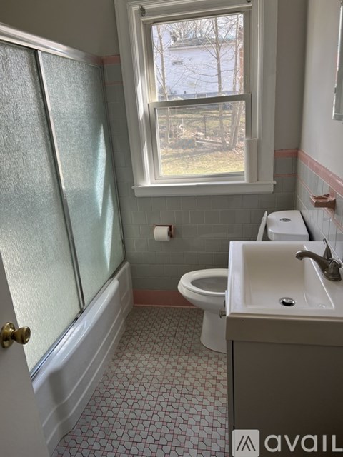 A bathroom with a toilet, sink, and tub.
