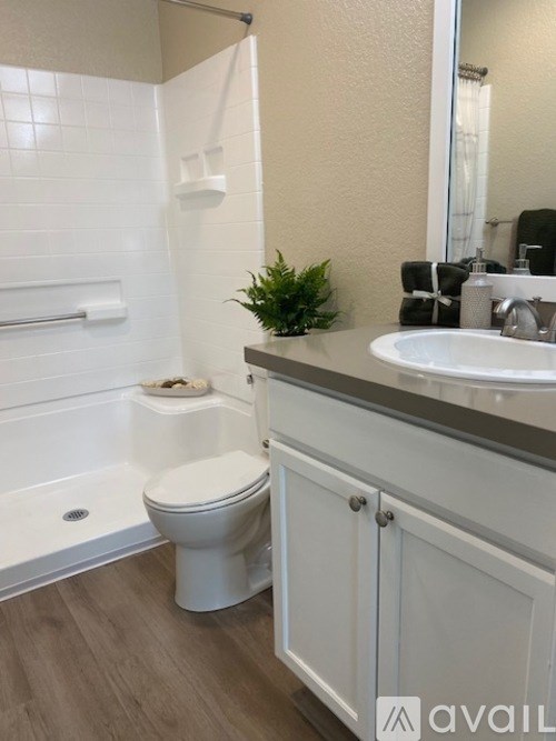 A white toilet sits in a bathroom next to a white sink.