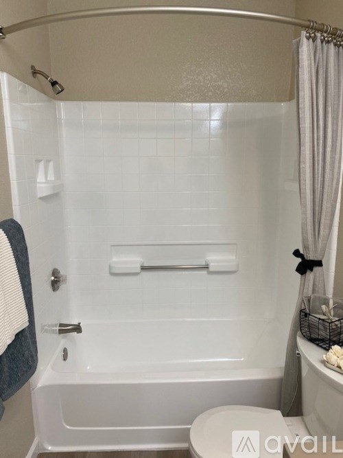 A white bathroom with a toilet, tub, and shower.