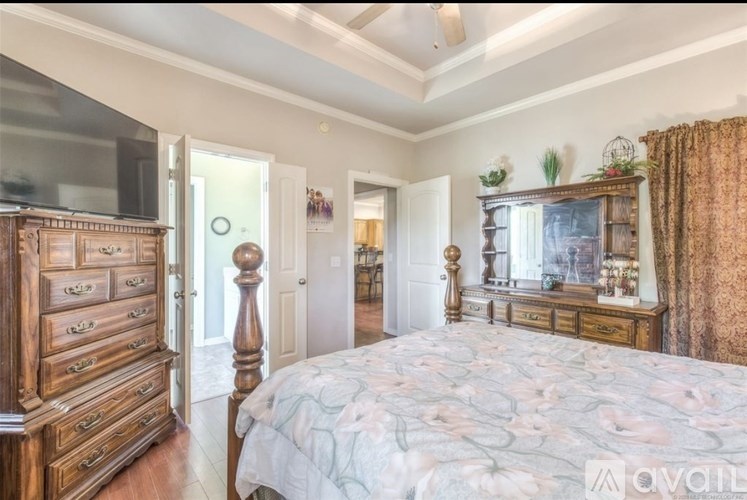 A bedroom with a large bed and wooden furniture.