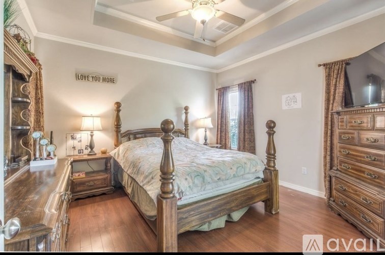 A bedroom with a large bed, wooden furniture, and a mirror on the wall.