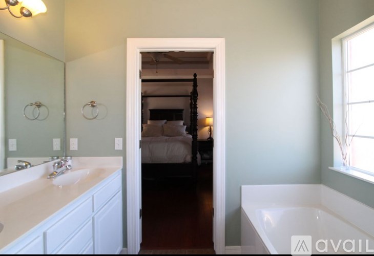 A bathroom with a white sink and a mirror above it.