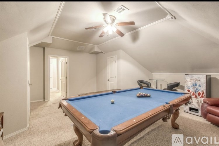 A pool table in a room with a ceiling fan.