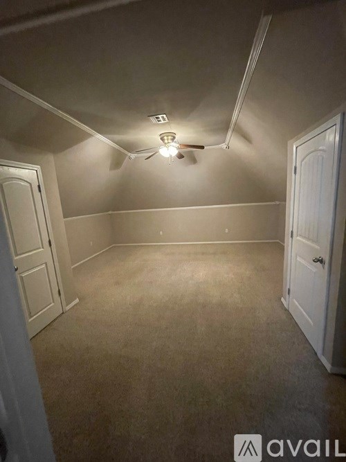 A room with a ceiling fan and two doors.
