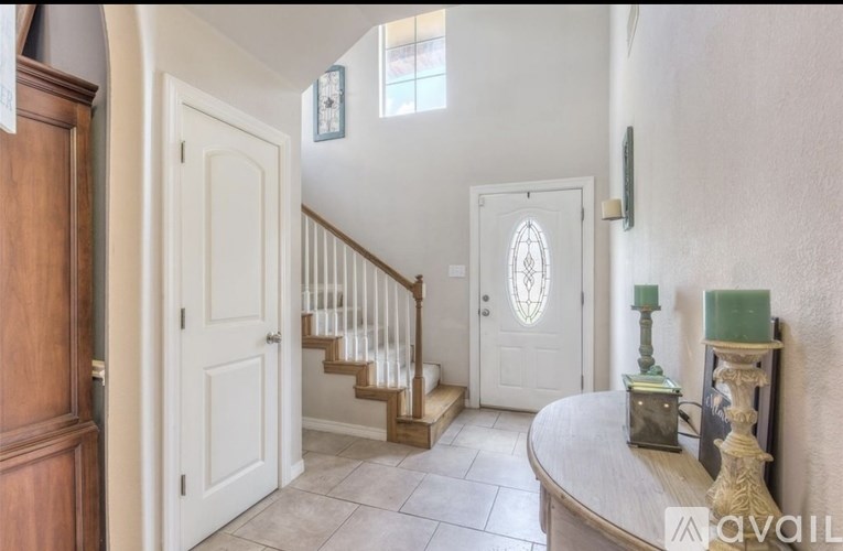 A foyer with a staircase and a white door.