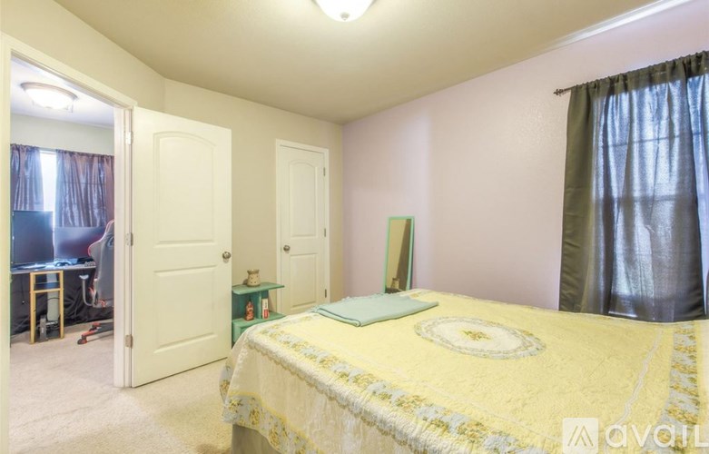 A bedroom with a bed, a desk, and a chair.