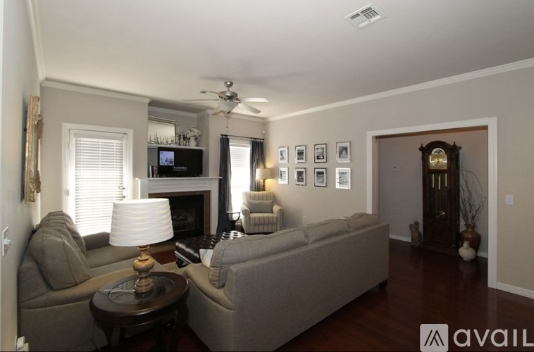 A living room with a grey couch, a coffee table, a fireplace, and a TV.