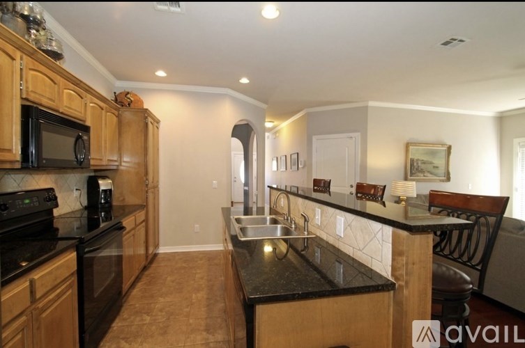 A kitchen with black countertops and wooden cabinets.