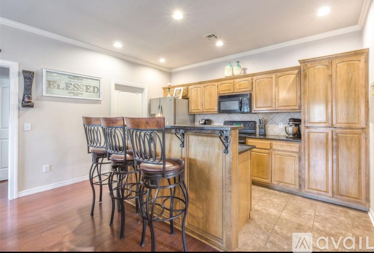A kitchen with wooden cabinets and a bar area.