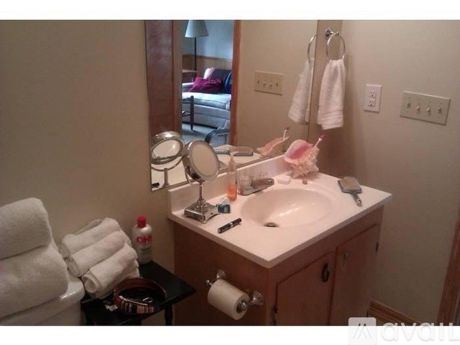 A bathroom with a sink, mirror, and towels.
