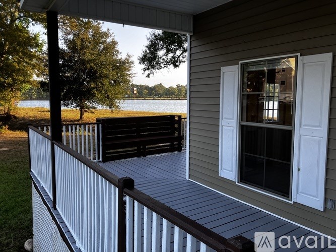 A house with a deck overlooking a lake.