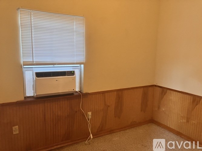 A room with a window and a wall-mounted air conditioner.