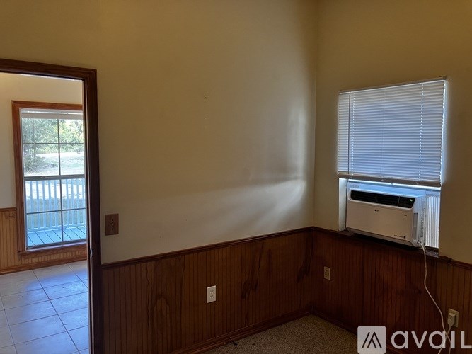 A room with a window and a wall-mounted air conditioner unit.