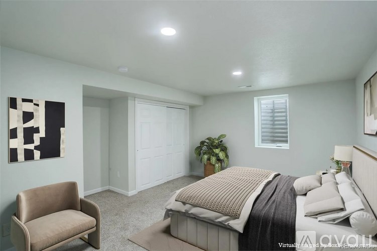 A bedroom with a bed, chair, and painting on the wall.
