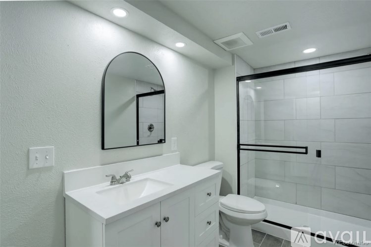 A bathroom with a white sink and toilet.